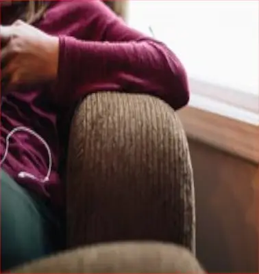 Person sitting alone thoughtfully on a couch, representing individual therapy in Bethesda, MD