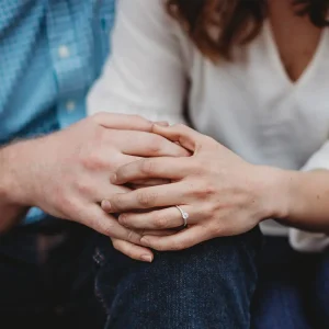 Couple sitting closely with clasped hands, illustrating recurring relationship conflict
