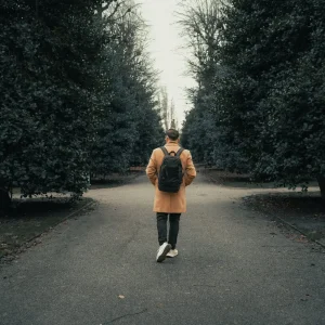 Man walking alone down a park path, representing depression in men