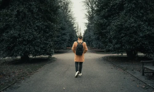 Man walking alone down a park path, representing depression in men